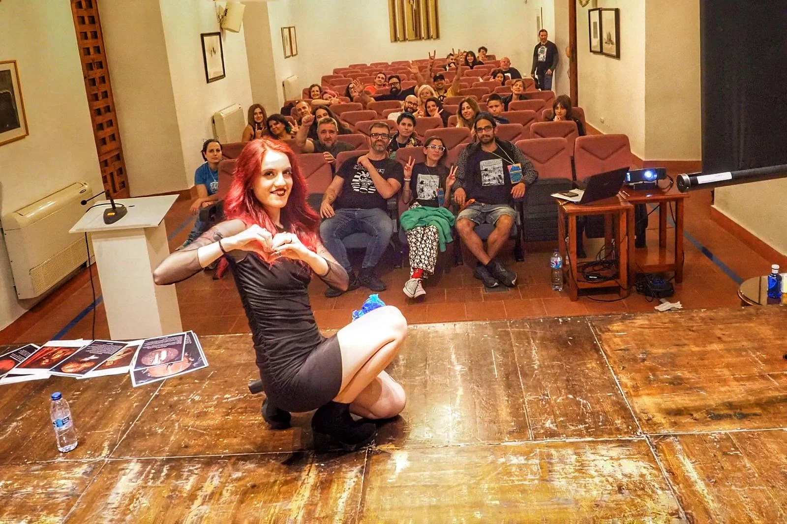 La cantante de filometal Eloisa de Castro posando en el escenario con el público detrás (parte del staff de ImaginaMálaga está en primera fila) después de su concierto.